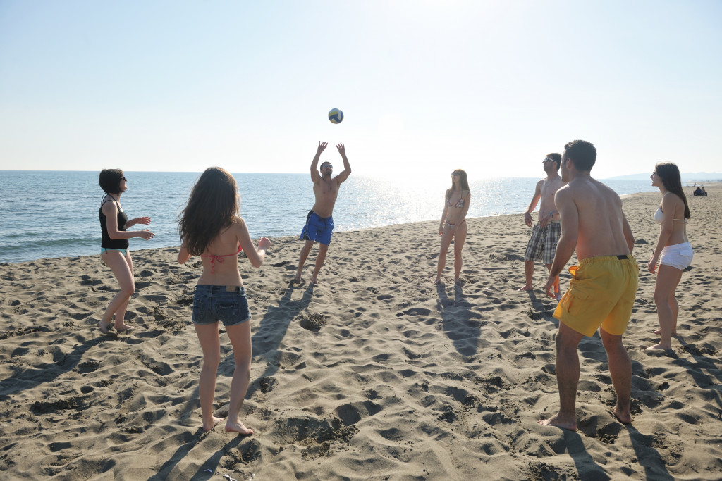 group of friends playing beach volleyball